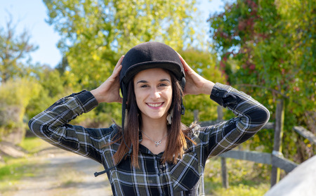 Portrait of a happy female jockey with an  helmet