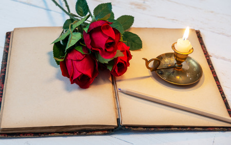 old notebook, roses and small candle, a  concept romanticの写真素材