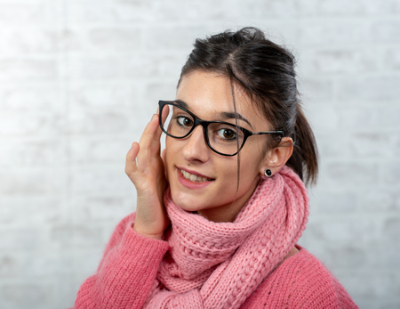 young smiling brunette woman with a pink sweaterの写真素材