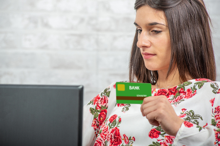 smiling young brunette woman buying with internetの写真素材