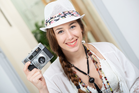 a beautiful hippie woman with a retro cameraの写真素材