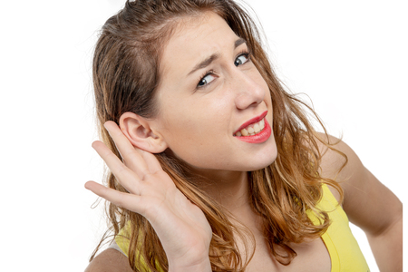 young woman listening gossip with her hand next to her earの写真素材