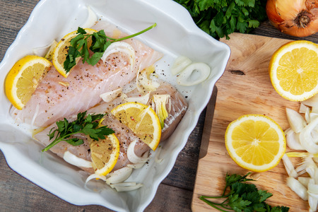 Fresh fish, a raw cod fillets with addition of herbs and lemon
