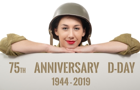 a young woman dressed in us wwii military uniform with helmet showing signboard with d-day...