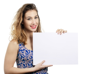 Happy smiling beautiful young woman showing blank signboard or copyspace for slogan or text, isolated on the white backgroundの写真素材