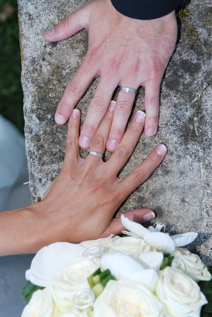 couple hands and rings on wedding bouquetの写真素材