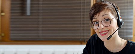 Smiling young woman using an headsetの写真素材