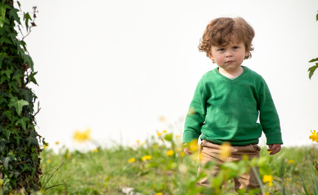 portrait of a young boy with green sweater playing outdoorsの写真素材