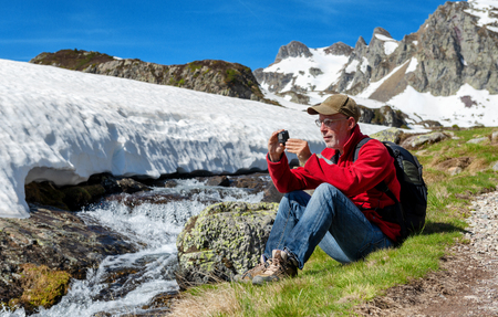 a hiker man take a picture with action cameraの写真素材