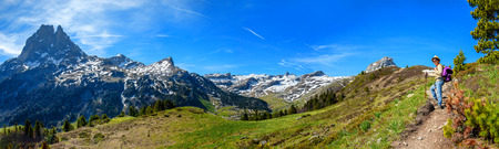 a hiker woman walking in the french Pyrenees mountains, Pic du midi d Ossau in backgroundの写真素材