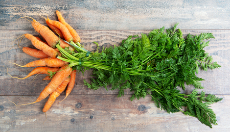 Fresh and sweet carrot on the wooden backgroundの写真素材