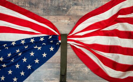 an American flag lying on an aged, weathered rustic wooden background.の写真素材