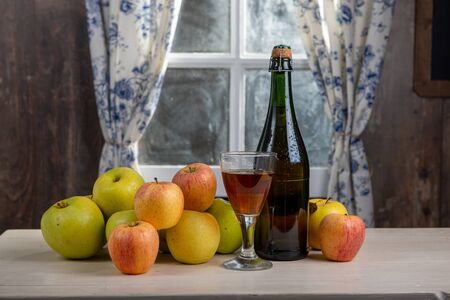 Bottle and glass of cider with apples. In a rustic houseの写真素材