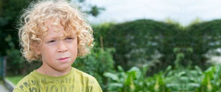 Portrait of a little boy with blond and curly hairの写真素材