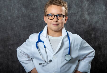 Cute kid boy wear medical uniform playing doctor, a portraitの写真素材