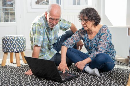 Couple senior using a computer laptop at home for online shoppingの写真素材