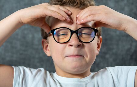 a boy with glasses has a headache