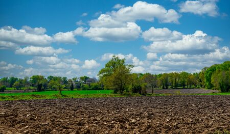 a plowed field and blue sky with cloudsの写真素材