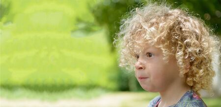 Portrait of a little boy with blond curly hairの写真素材