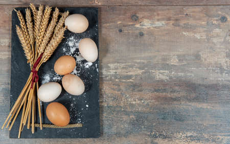 fresh eggs and some wheat ears, a copy space