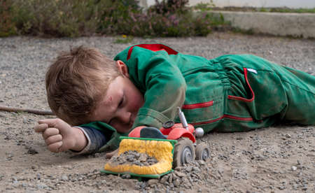 a dirty child playing ground with tractor toyの写真素材