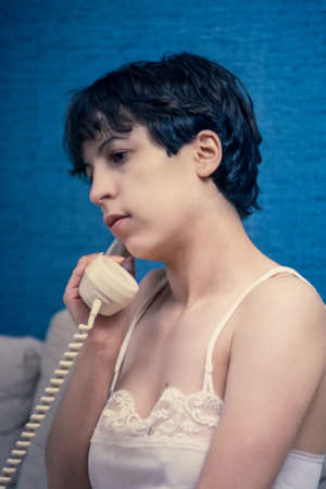 pretty young brunette with an antique telephoneの写真素材