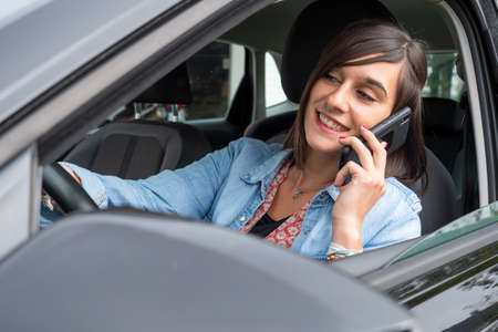 Woman uses mobile phone in a car