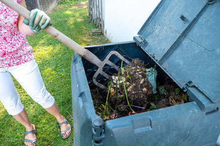 A woman and outdoor compost bin to reduce waste