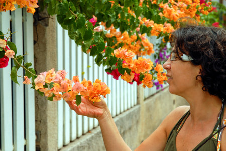 a beautiful mature woman smells flowersの写真素材