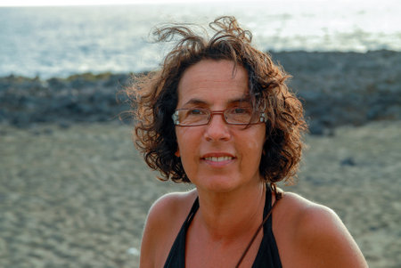 portrait of a pretty tanned mature woman with glassesの写真素材