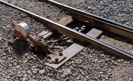 A train track with a red and white signal on the ground. The signal is missing a boltの写真素材