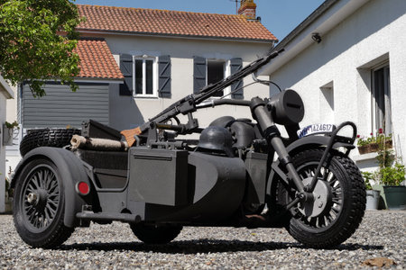 Motorcycle with a sidecar and a gun on it. The motorcycle is parked in front of a houseの写真素材
