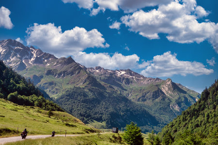 Mountain range with a clear blue sky. There are two people on the motorcycle