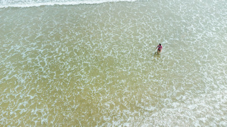 Aerial view of a man swimming in the sea in the beach