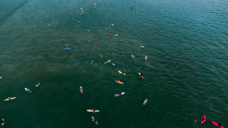 Aerial view of a group of people surfing in the sea.