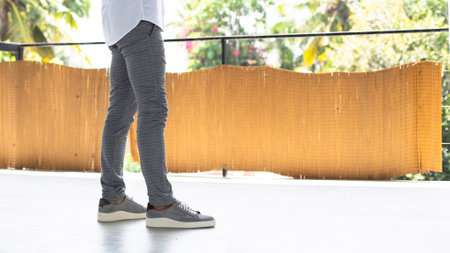Men's legs in leggings and sneakers on the balcony.の写真素材