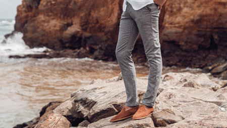 Handsome young man in casual clothes posing on the beach.