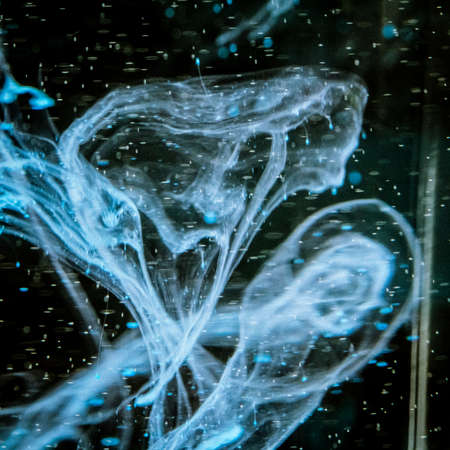 watercolor drops in a glass of water, close upの写真素材