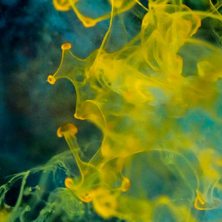 watercolor drops in a glass of water, close upの写真素材