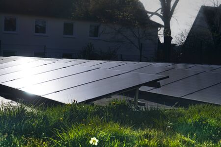 Solar cells on grassland with light beams from front to back in a living district.