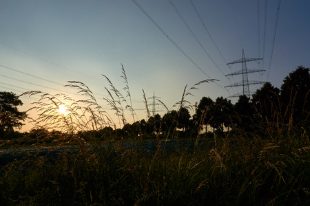 two power poles and sunrays from a sunsetの写真素材