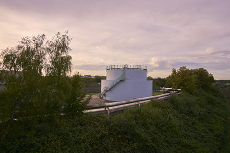 a oil tank and rails with a cloudy skyの写真素材