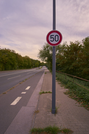 a street with a traffic sign and treesの写真素材