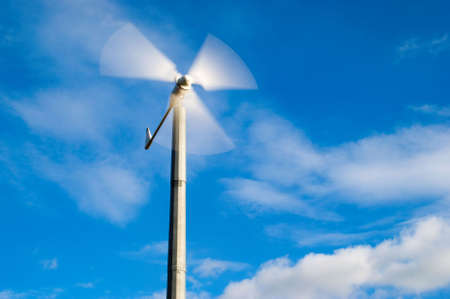 wind turbine against deep blue sky with white cloudsの写真素材
