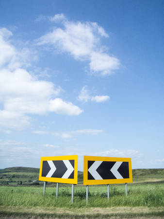 Road sign with arrows pointing both waysの写真素材