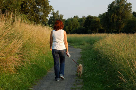 Girl walks her dog in a parkの写真素材