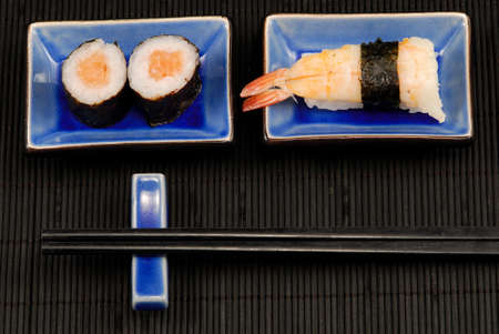 Chopsticks and sushi on black bamboo matの写真素材