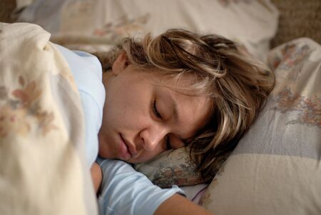 Young woman sleeping in bedの写真素材