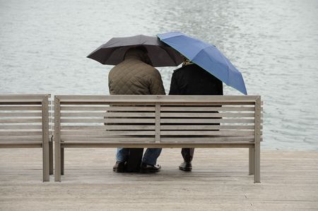 Couple with umbrellas in Barcelona, Spainの写真素材