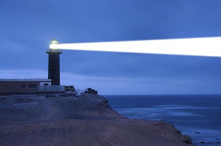 Lighthouse searchlight beam through foggy air. Punta Jandia, Fuerteventuraの写真素材